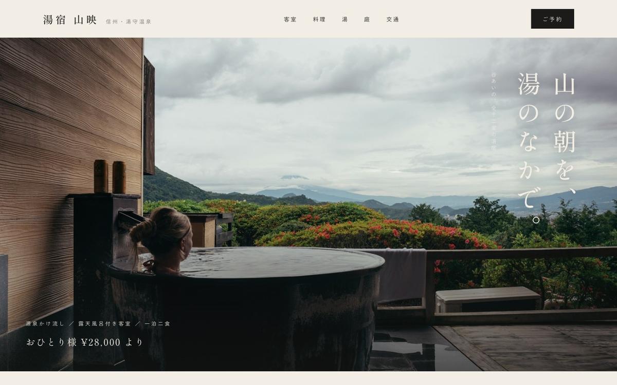 大きな露天風呂の写真と縦書きの明朝見出しを使った旅館サイト